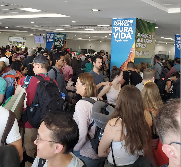 Viajeros haciendo fila en migración al llegar a Costa Rica